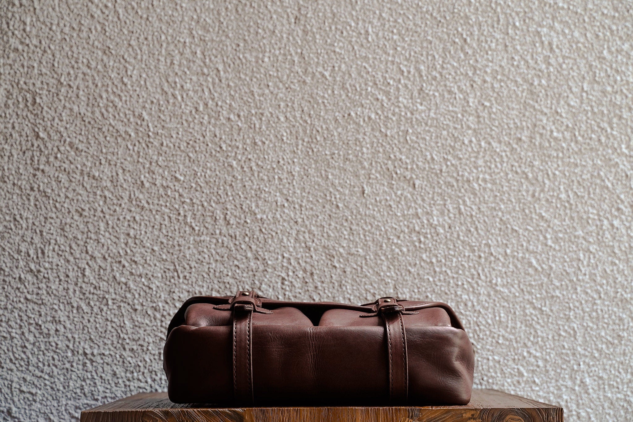 One of our signature design cues, the body straps go all around the bag, providing a load bearing structure for the bag. Keeping with the goal to minimize seams, the sides and bottom are made from one big piece of leather.