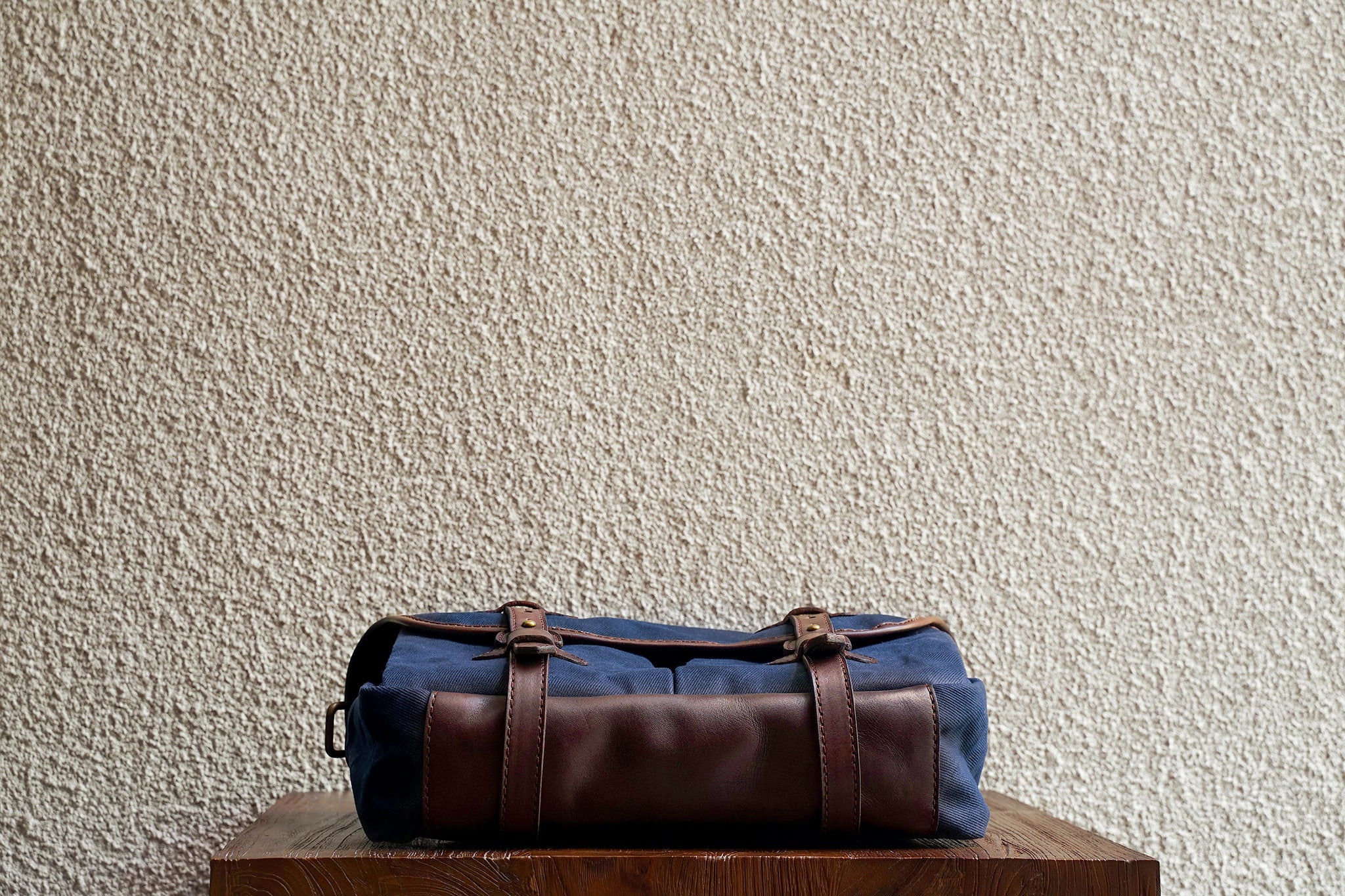 One of our signature design cues, the body straps go all around the bag, providing a load bearing structure for the bag. A big piece of leather on the bottom adds to the durability of the bag.