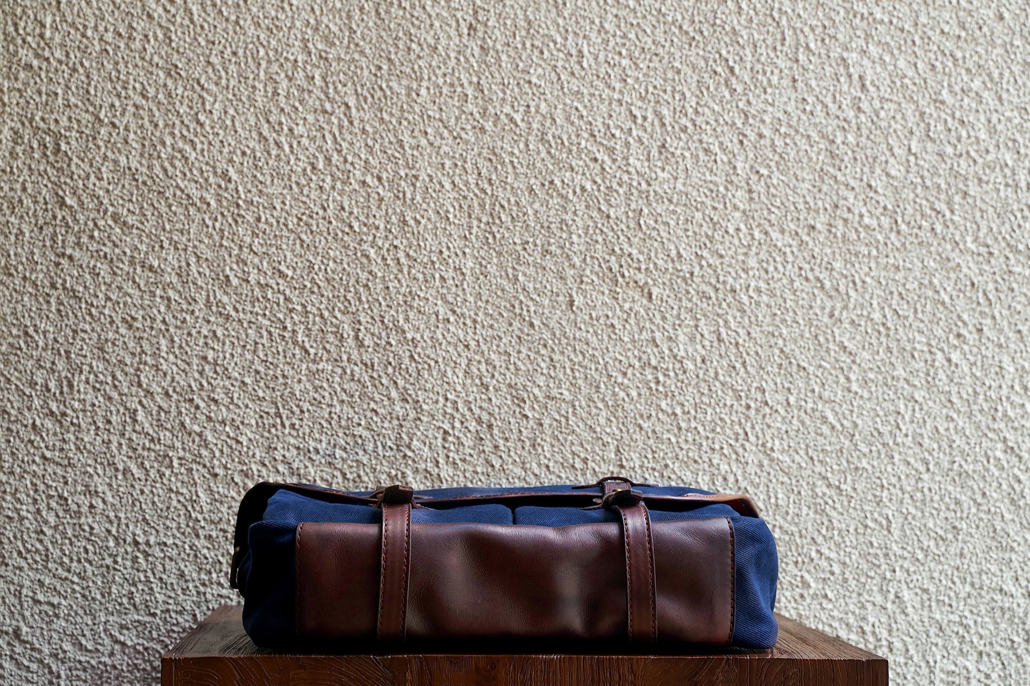 One of our signature design cues, the body straps go all around the bag, providing a load bearing structure for the bag. A big piece of leather on the bottom adds to the durability of the bag.