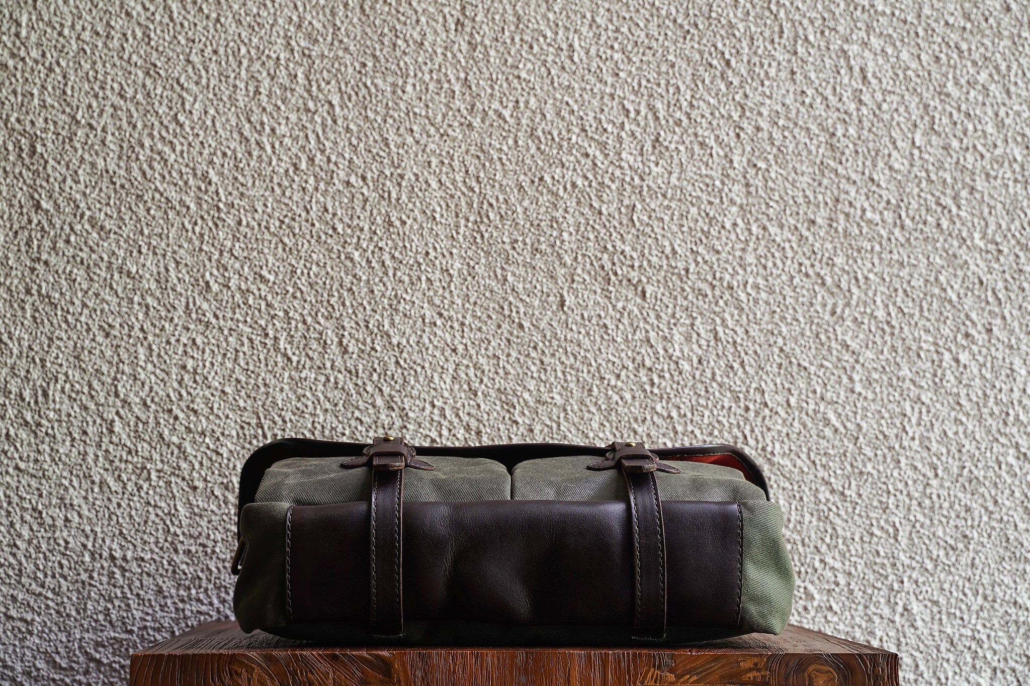 One of our signature design cues, the body straps go all around the bag, providing a load bearing structure for the bag. A big piece of leather on the bottom adds to the durability of the bag.